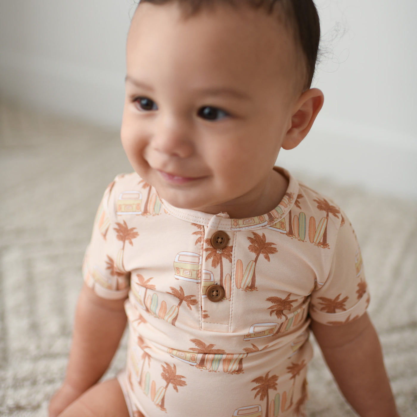 Waikiki short sleeve organic cotton unisex baby and toddler bodysuit with palm trees, longboard surfboards and combi wagon / van in an earthy colour palette.